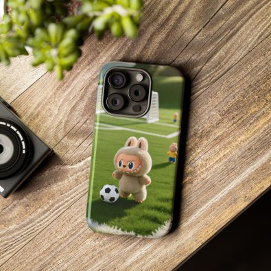 A playful bunny wearing a soccer jersey holding a phone in its paws, surrounded by soccer balls and green grass